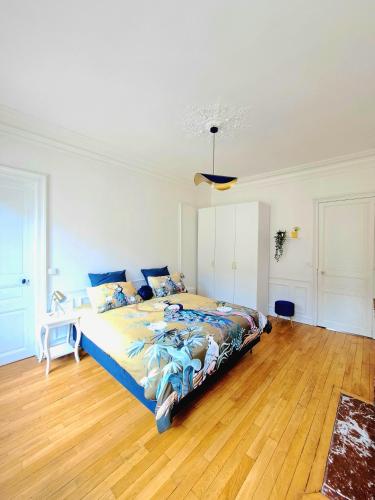 une chambre avec un grand lit et un parquet dans l'établissement L'Instant Rémois - Hypercentre Boulingrin, à Reims