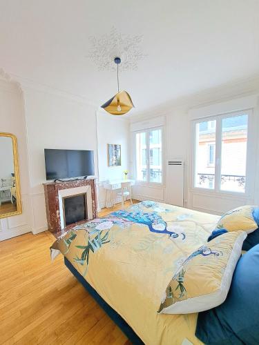 - une chambre avec un grand lit et une cheminée dans l'établissement L'Instant Rémois - Hypercentre Boulingrin, à Reims