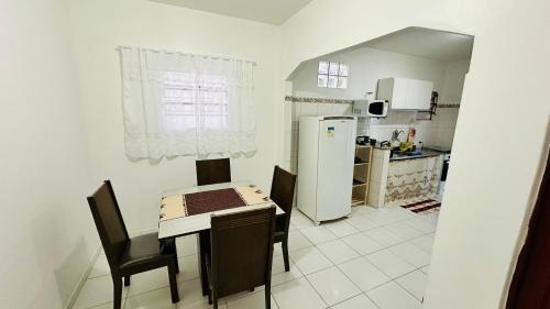 una cucina con tavolo, sedie e frigorifero di Casa Jardim Colorado a Vila Velha