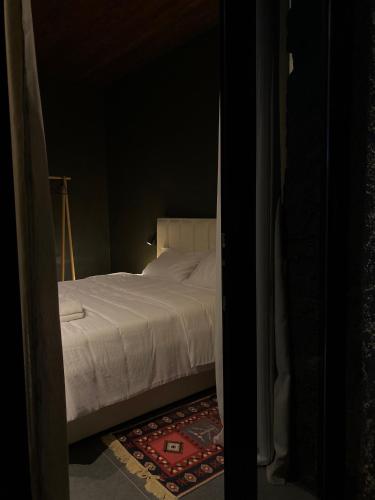 a bedroom with a white bed and a rug at Art House Kruje in Krujë