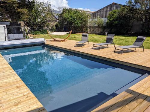 - une piscine avec 2 chaises et un hamac dans la cour dans l'établissement Ty glaz- Piscine privé chauffé securisé -Plage 700m, au Guilvinec