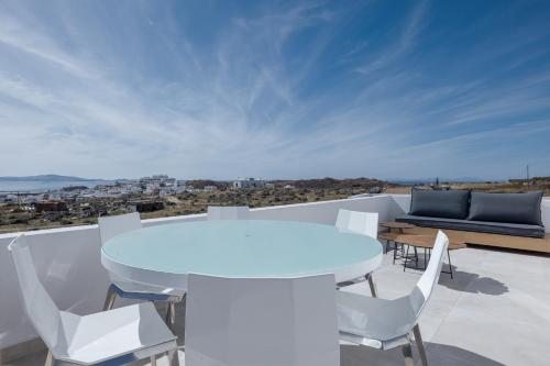 a white table and chairs on a balcony with a view at El Mar Naxos in Naxos Chora