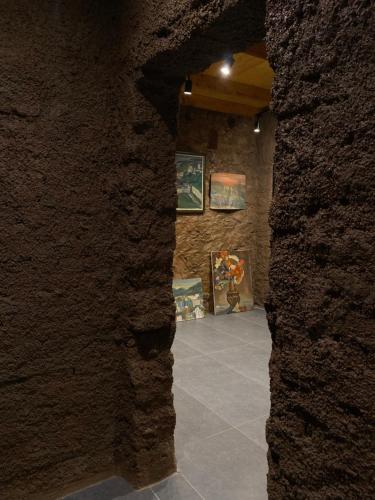 a view through a stone wall into a room with paintings at Art House Kruje in Krujë
