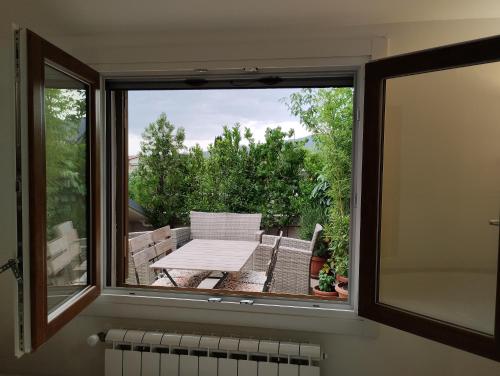 a window with a table and a bench on a balcony at Bellini's House in Montecatini Terme
