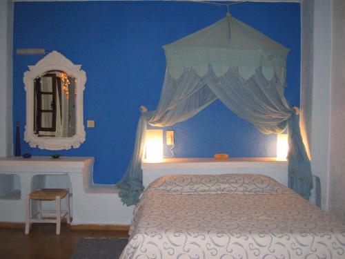 a blue bedroom with a bed and a mirror at Cretan Village Hotel in Agios Nikolaos
