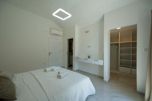 a white bedroom with a bed and a bathroom at The Golden Luxury Apartments in Kotor