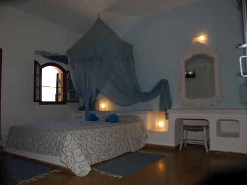 a bedroom with a bed with a dresser and a mirror at Cretan Village Hotel in Agios Nikolaos