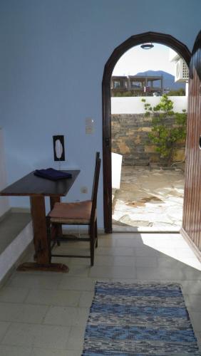 a table and a chair in a room with an open door at Cretan Village Hotel in Agios Nikolaos