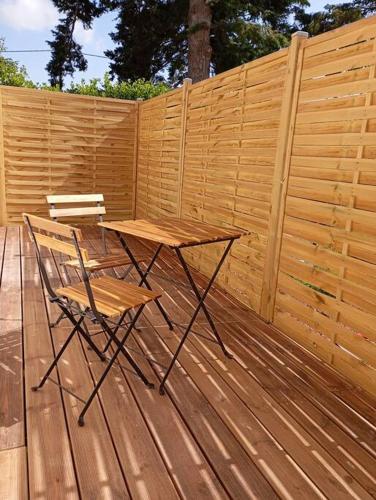 une table en bois et une chaise sur une terrasse dans l'établissement Appart Binic - Le grain de sable, à Binic