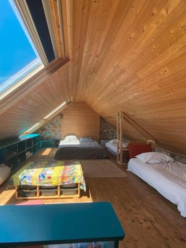 une grande chambre avec deux lits et une table bleue dans l'établissement Maison en bord de mer - Plougastel-Daoulas - 6 à 8 personnnes, à Plougastel-Daoulas