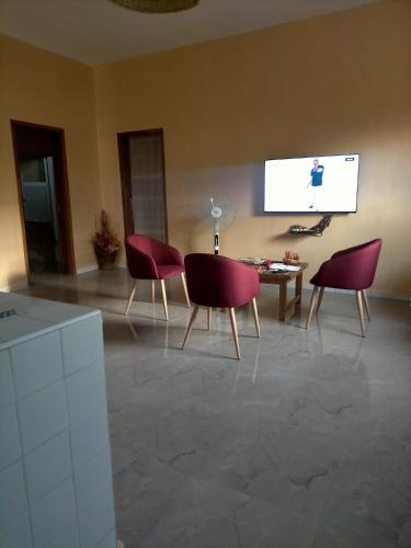 a living room with two chairs and a table and a screen at Auberge Andel Diabou SARR in Palmarin