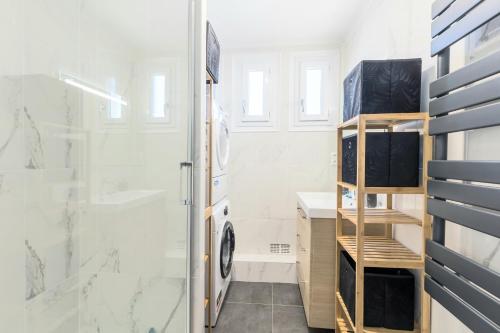 a bathroom with a shower and a washing machine at Jolie T5 familial 10p in Coulaines