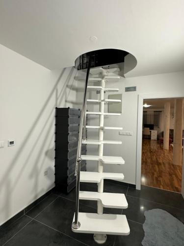 a spiral staircase in a room with a white wall at Villa KIBA in Hadžići