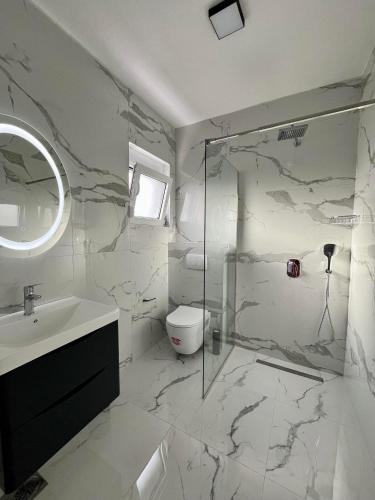 a white bathroom with a sink and a toilet at Street Apartments in Ulcinj