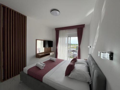 a bedroom with a bed and a tv and a window at Street Apartments in Ulcinj