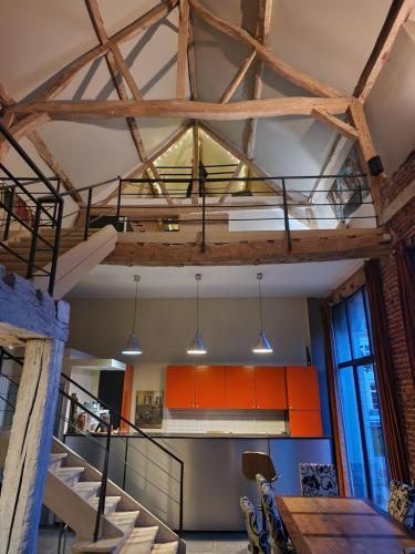 un loft avec un escalier et des armoires orange dans l'établissement Château d'Humieres - Casa Allegro, à Humières