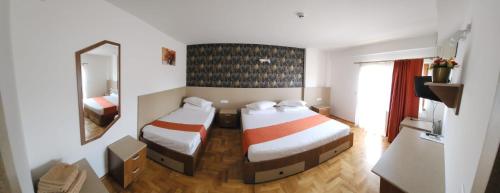 a hotel room with two beds and a mirror at Complex Ramiro in Suceava