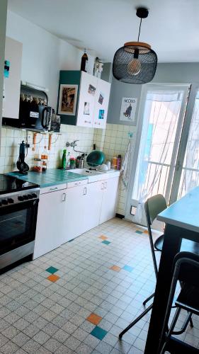 a kitchen with white cabinets and a table and a table and a table at Chambre dans appartement agréable et calme à 15 mn du Centre Ville in Annecy