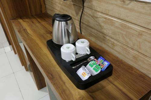 a black tray with a coffee maker on top of a counter at Hotel Aurora Mirage Delhi in New Delhi
