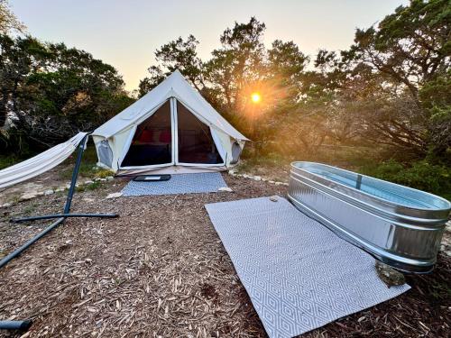 uma tenda com uma cama e uma banheira num campo em The Juniper Ranch and Retreat em Canyon Lake