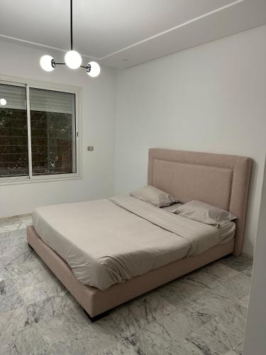 a bedroom with a large bed in a white room at Glamorous Spacious 3BR at Jardin de Carthage Tunis in Sidi Daoud