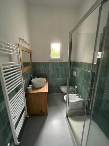 a bathroom with two toilets and a sink and a shower at Poveromo B&B in Massa