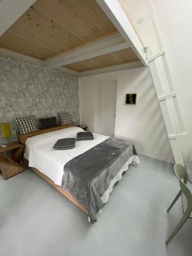 a bedroom with a large bed and a chair at Poveromo B&B in Massa