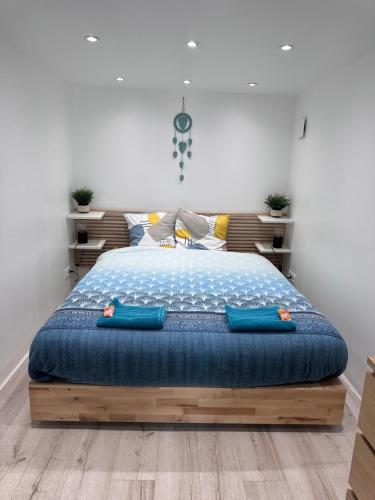 Schlafzimmer mit einem Bett mit blauer Bettwäsche und Kissen in der Unterkunft Home Jardin du Luxembourg à Paris in Paris