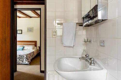 a bathroom with a sink and a bedroom with a bed at Encantadora Casa con bosquecito in San Carlos de Bariloche