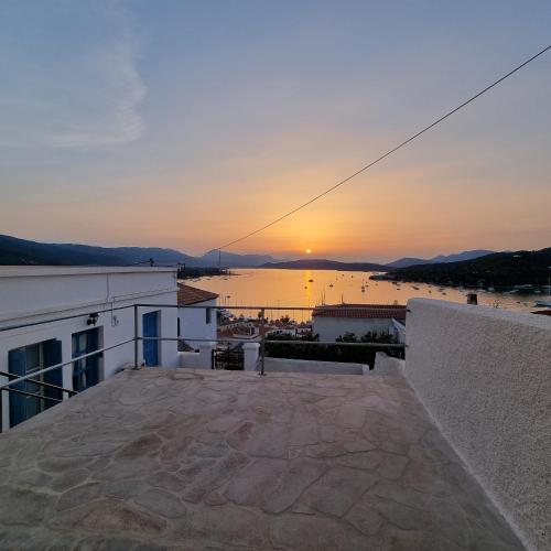 a view of the sunset from the balcony of a building at Panoramic View apartment in Poros
