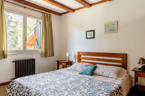 a bedroom with a bed and a window at Encantadora Casa con bosquecito in San Carlos de Bariloche