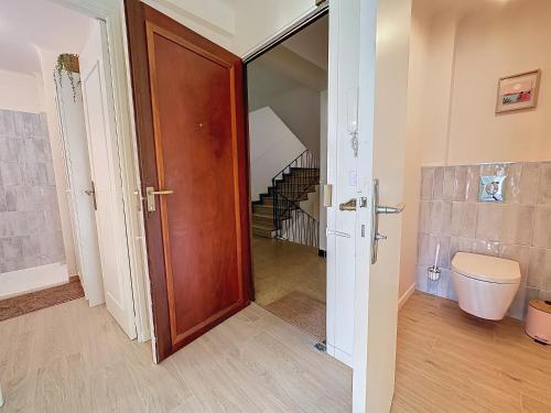 La salle de bains est pourvue d'une porte en bois et d'un escalier. dans l'établissement 63m2 Grande Terrasse, Climatisation & Parking, 2BR, à Cannes