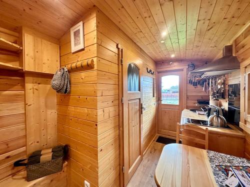 a log cabin kitchen with a wooden wall at Zauberwagen am Geiseltalsee in Stöbnitz