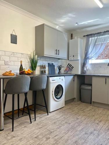 a kitchen with a table and a washing machine at Stylish apartment in The City Centre in Kingsthorpe