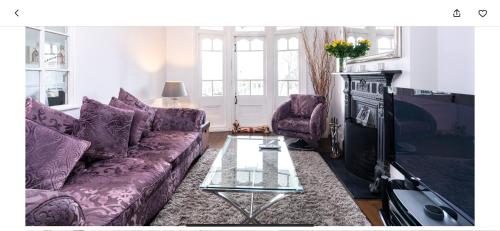 a living room with purple couches and a tv at Stunning sea views from rooms and terraces in Leigh-on-Sea