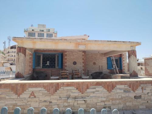 a small brick house on top of a stone wall at Ageeba Beach Challet 17 in Marsa Matruh