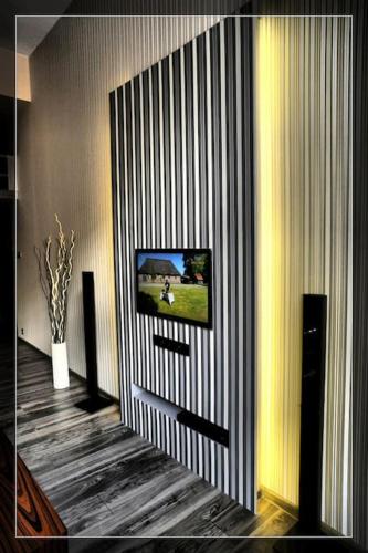 a living room with a television on a wall at Vision Luxury Apartment Rynek in Wrocław