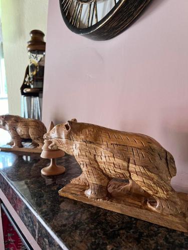two wooden statues of a bear on a table at Rustic House in Miléa