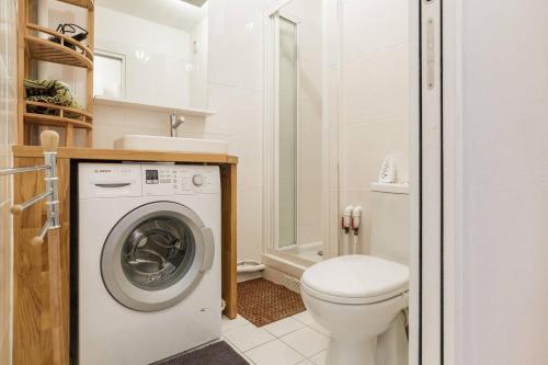 une salle de bain avec machine à laver et toilettes dans l'établissement Cozy Studio Bastille with balcony, à Paris