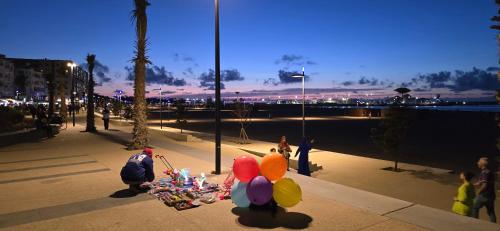 a group of people sitting around a table with balloons at Appartement charmant au parc de Mohammedia, à seulement 2 pas de la plage in Mohammedia