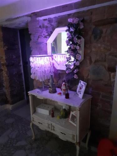 a dressing table with a mirror and purple lights at La casa di baggioro in Castelvecchio
