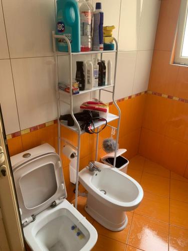 a small bathroom with a toilet and a sink at Apartment City Center Fier in Fier