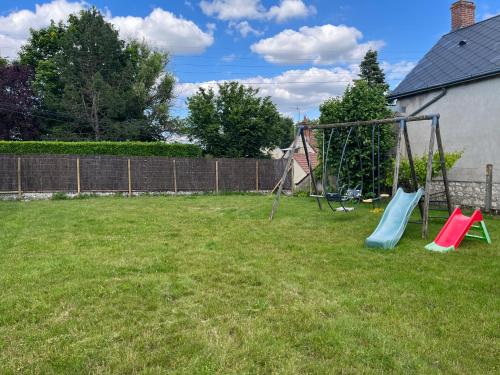 a yard with a playground with two swings at Le Pressoir Macy - Terracobois in Choussy