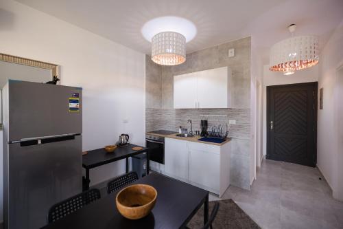 a small kitchen with a refrigerator and a table at 2BR Chalet Direct on swimming pool Ain Sokhna in Ain Sokhna