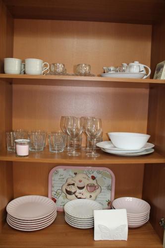 a shelf with plates and wine glasses and dishes at La Pesciatina in Pescia