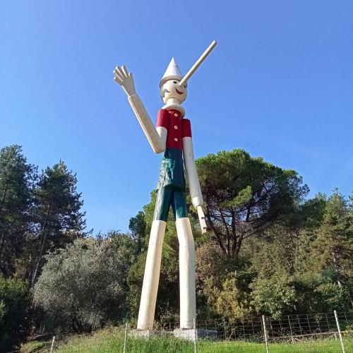 a large statue of a person standing in a field at La Pesciatina in Pescia
