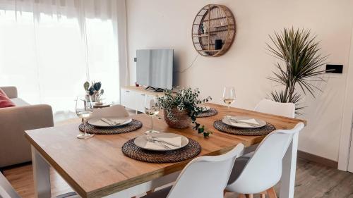 einen Holztisch mit weißen Stühlen und ein Esszimmer in der Unterkunft O Lar de Laura in Vigo