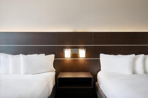 two beds in a hotel room with white pillows at Holiday Inn Express & Suites Spring Hill by IHG in Spring Hill