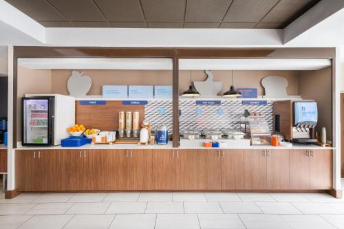 a view of a kitchen in a restaurant with a counter at Holiday Inn Express & Suites Spring Hill by IHG in Spring Hill
