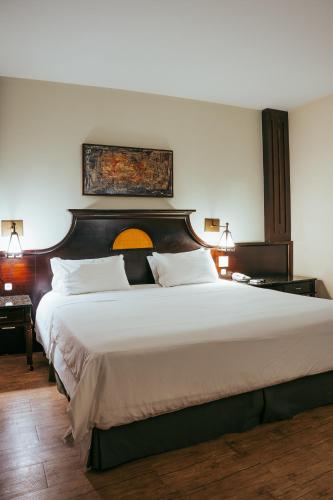 a bedroom with a large bed with a wooden headboard at Batel Luxury - Próx Pátio Batel in Curitiba